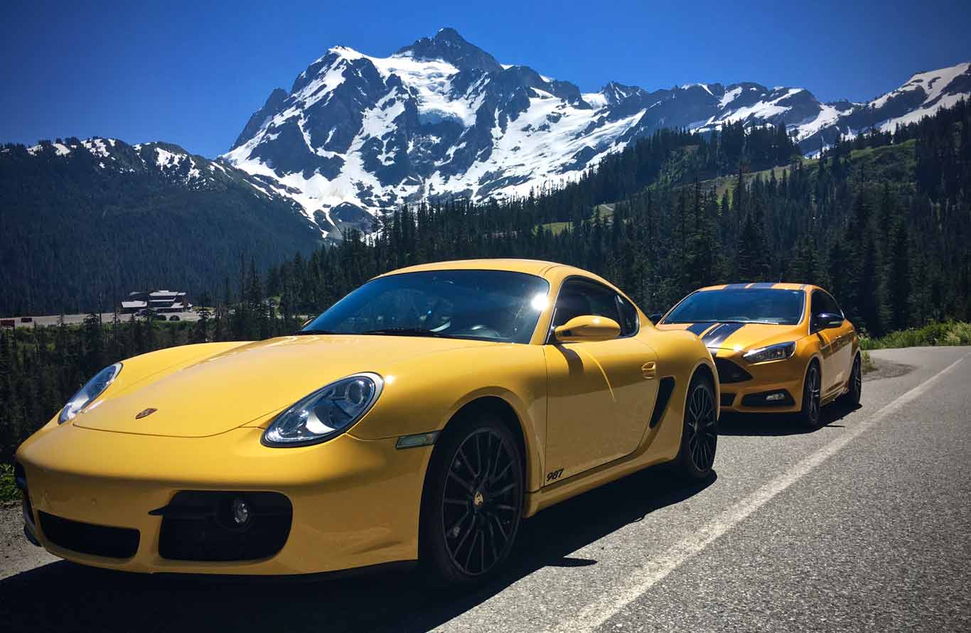 Foto de portada de dos autos deportivos amarillos brillantes frente a una majestuosa vista montañosa cubierta de nieve