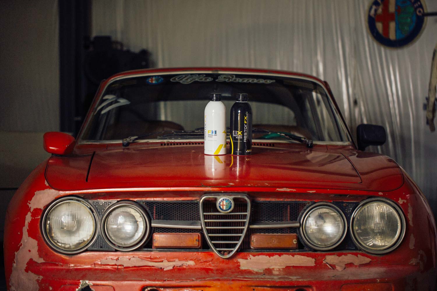 Bouteilles de produits RestorFX F et X sur le capot d'un millésime 1967 rouge Alfa Romeo Giulia Coupé 1750 GTV