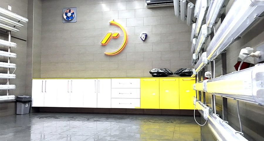 Área de trabajo prístina dentro de un Centro RestorFX con paneles de luz y estanterías y paredes con la marca amarilla y blanca