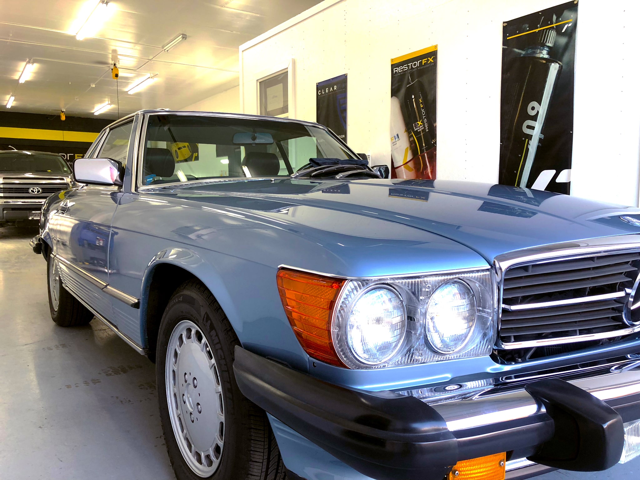 Brilliantly clear, reflective, shiny, glossy and smooth classic blue Mercedes car after ClearFX protection maintenance