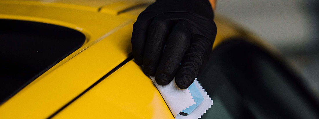 Un técnico de RestorFX que protege la superficie pintada de un auto deportivo amarillo brillante con el producto <span  class='notranslate'><span  class='notranslate'>ClearFX</span> Exterior</span>