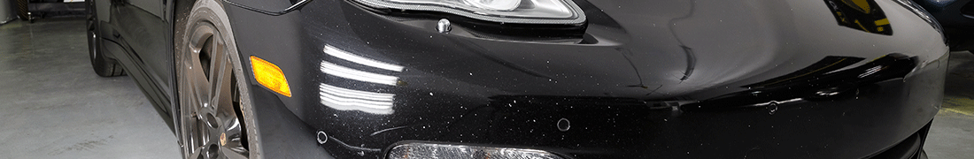 Superficie de pintura astillada y abollada en el área del parachoques delantero de un automóvil negro antes de la reparación de astillas de pintura RestorFX con el <span  class='notranslate'>FX Paint System</span>