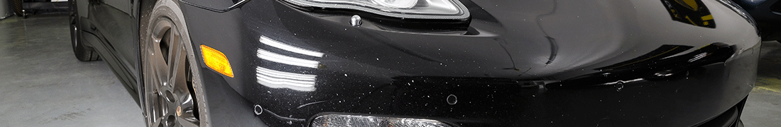 Chipped and dinged front bumper area paint surface of a black car before RestorFX Paint Chip Repair with FX Paint System