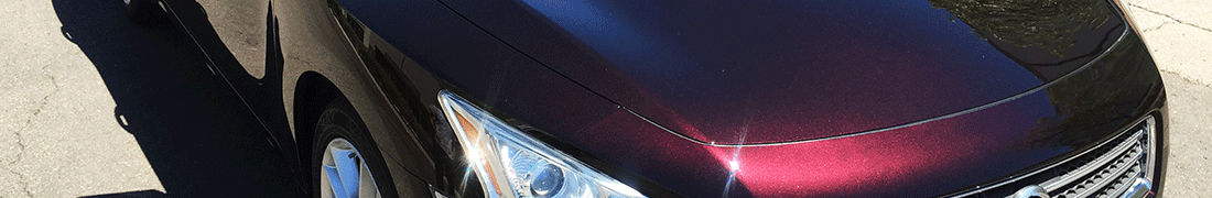 Shiny, sparkly, brilliantly reflective red sedan with smooth surface and shiny headlights after a RestorFX treatment