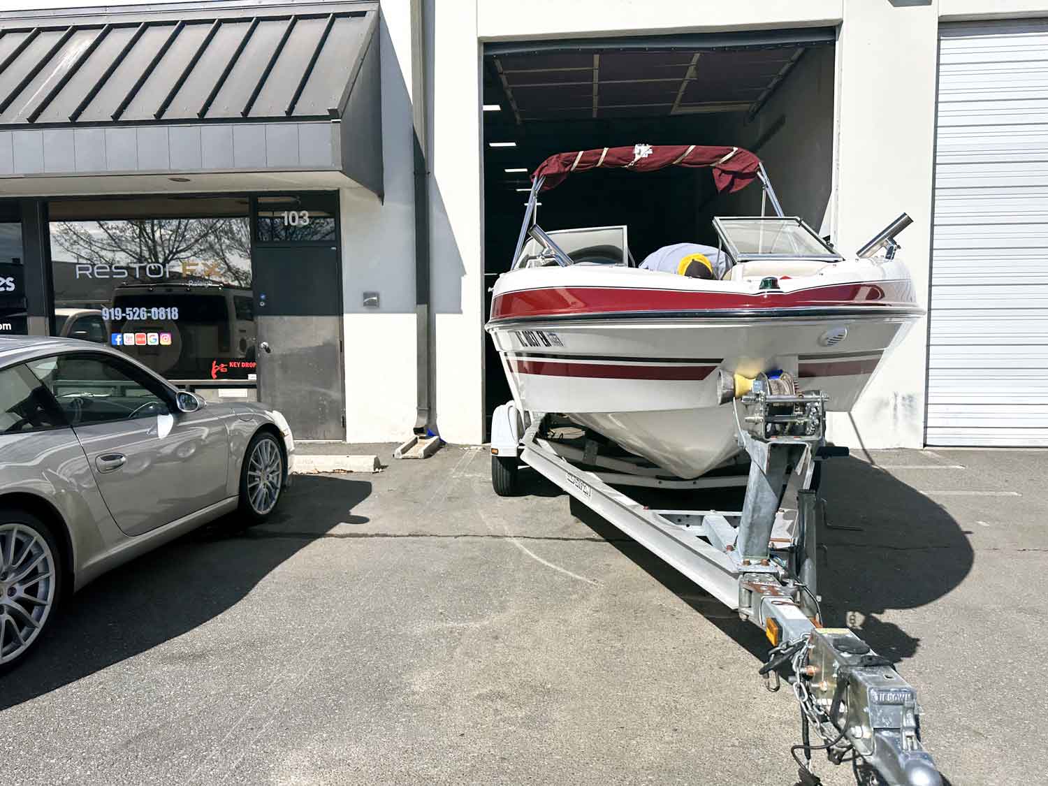 A boat parked in front of the RestorFX Raleigh center door with a branded window front