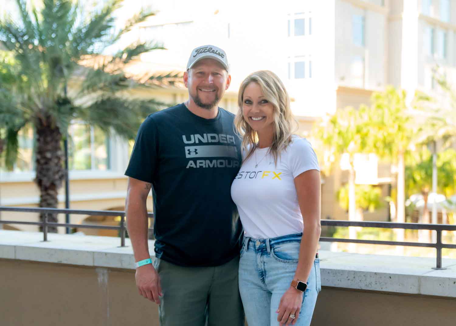 RestorFX Evansville team standing in branded apparel outside in a sunny area with palm trees in the background