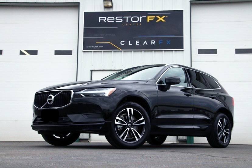 Escaparate de RestorFX Utah-Clearfield con paredes de edificio blancas y un SUV Volvo negro brillante