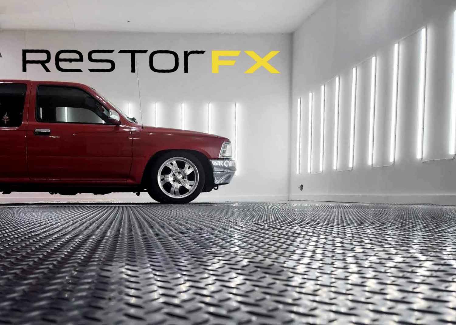 Espace de magasin RestorFX West Niagara avec un low rider rouge garé et entouré de lumières vives