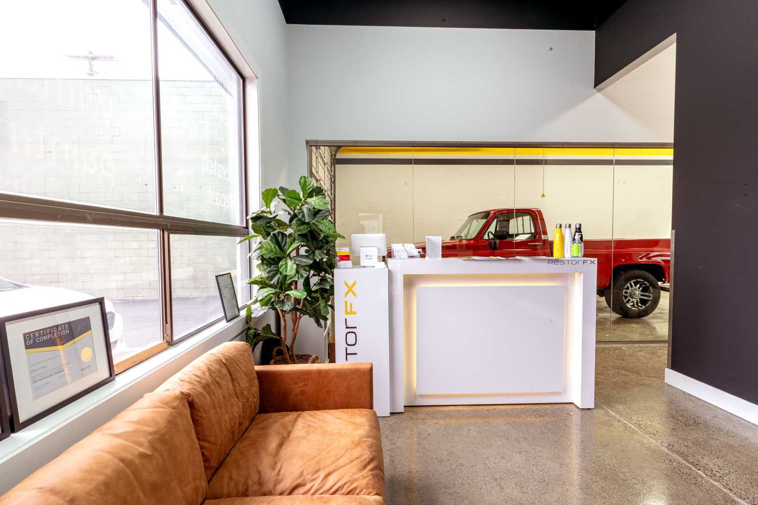 Bright and modern RestorFX client lounge with a white counter area and big glass windows