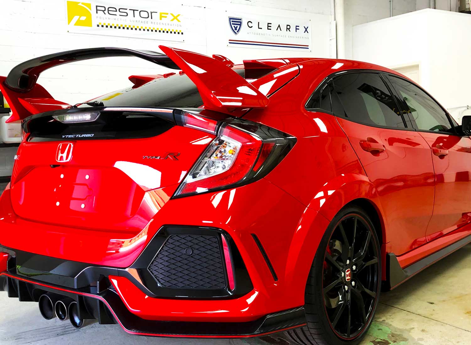 Shiny red Honda after RestorFX application at brightly lit RestorFX Mississauga shop area