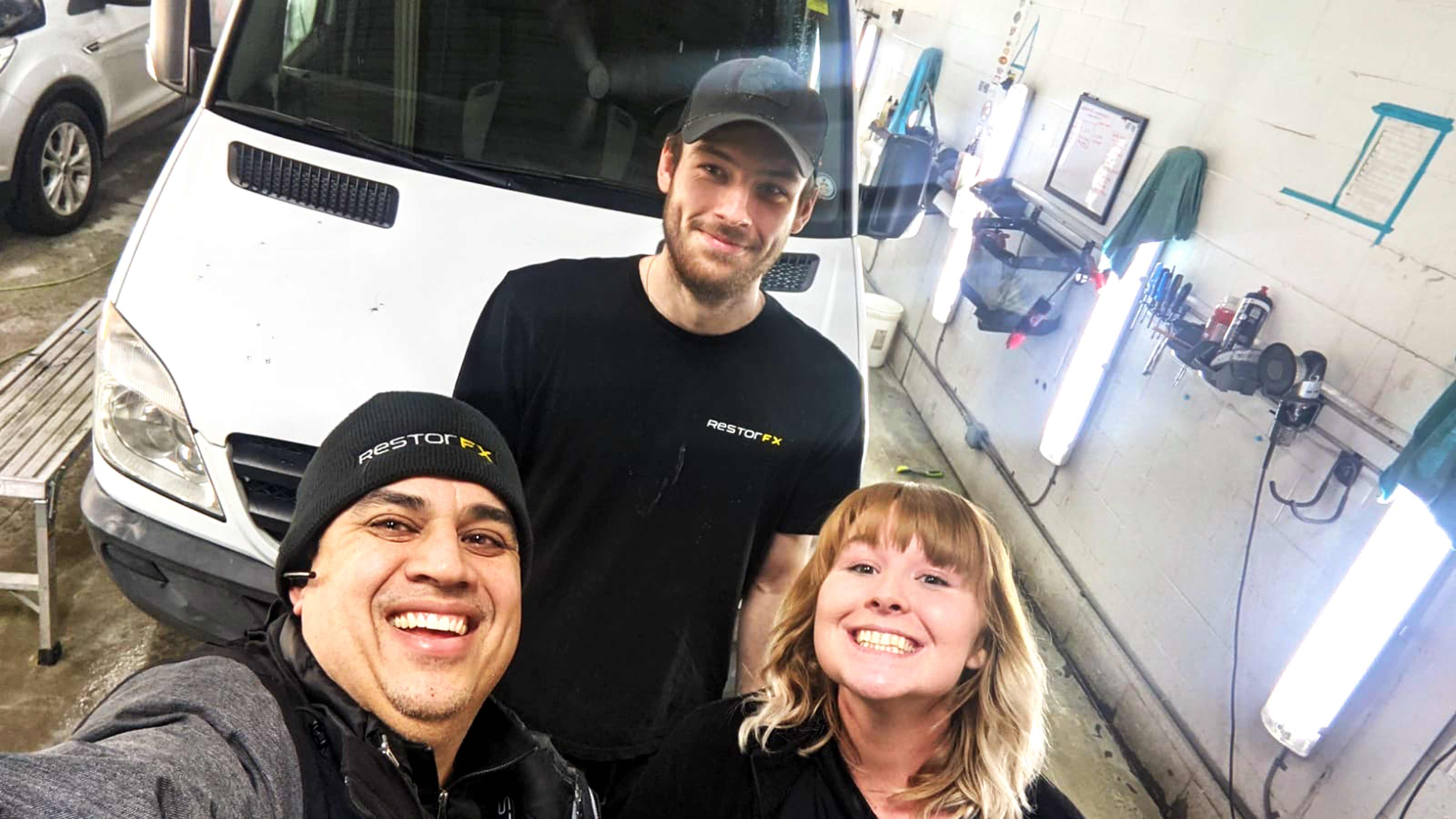 RestorFX Barrie team selfie at the Center shop area with a white van in the background before restoration