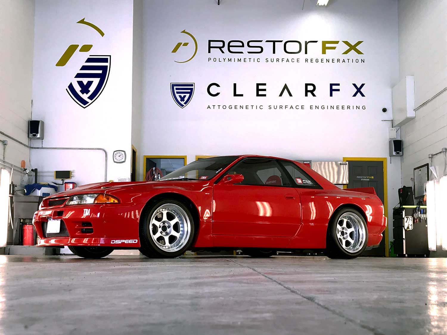 RestorFX GTA shop area with a bright red sports car inside the brightly lit facility with tall ceilings