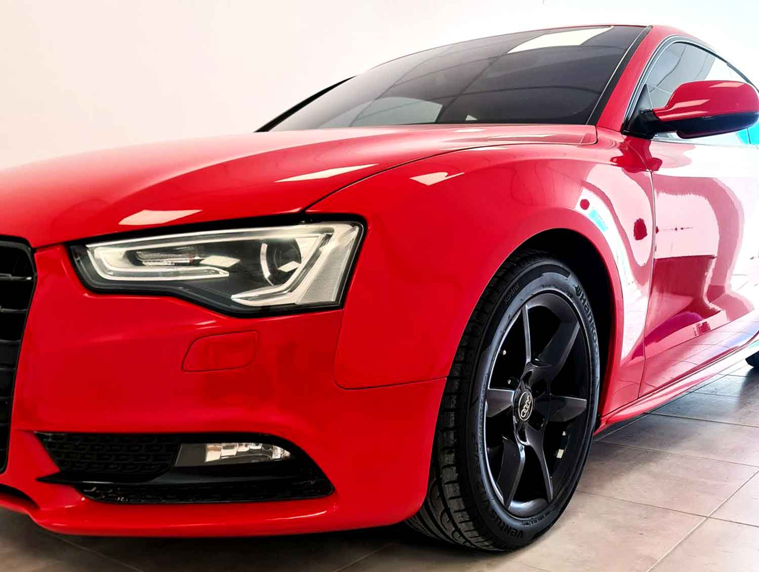 Shiny red vehicle at RestorFX Madryn with white wall in the back