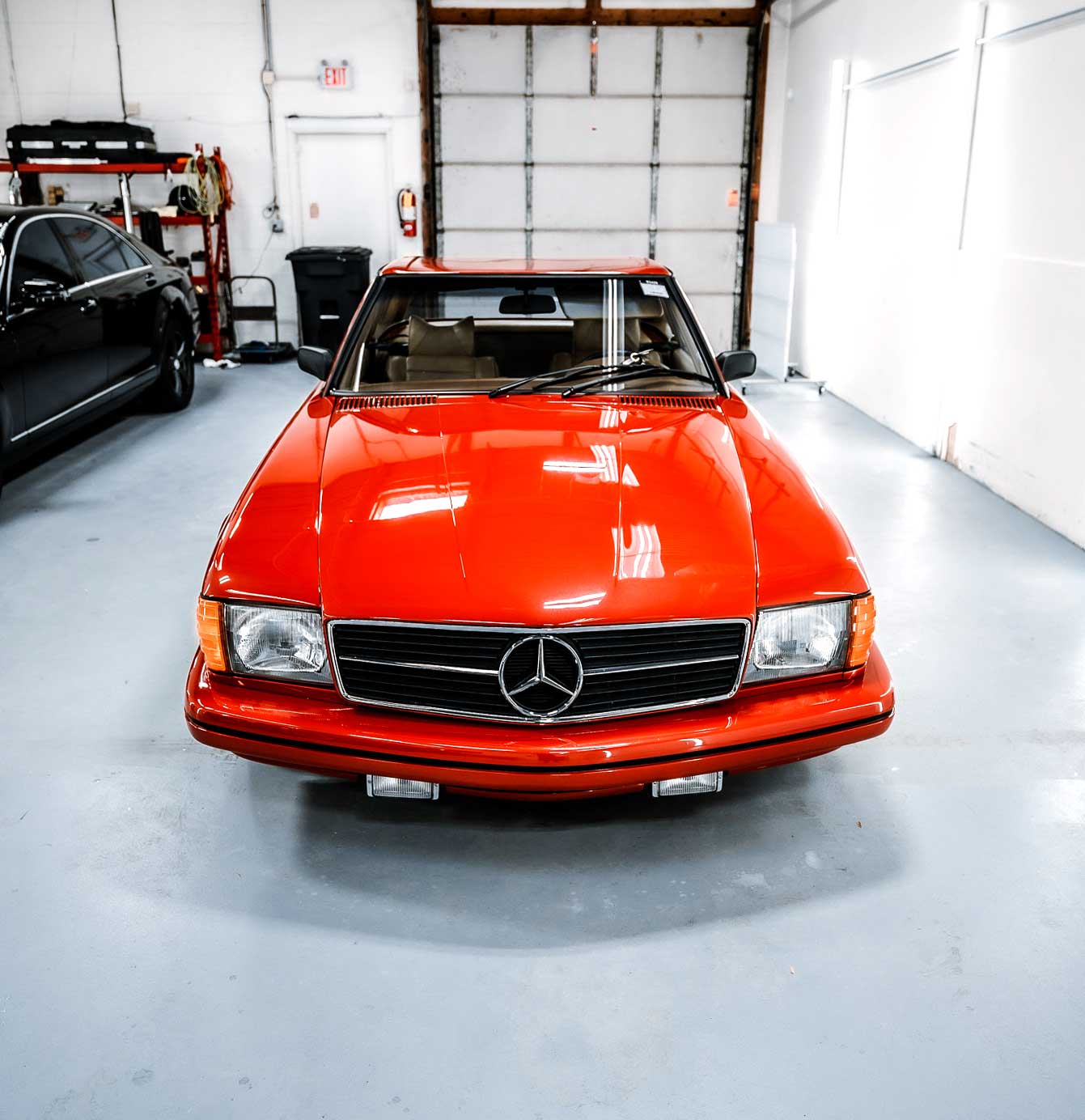 Glossy red Mercedes-Benz SL in center of brightly lit and spacious shop area at RestorFX Wood Dale