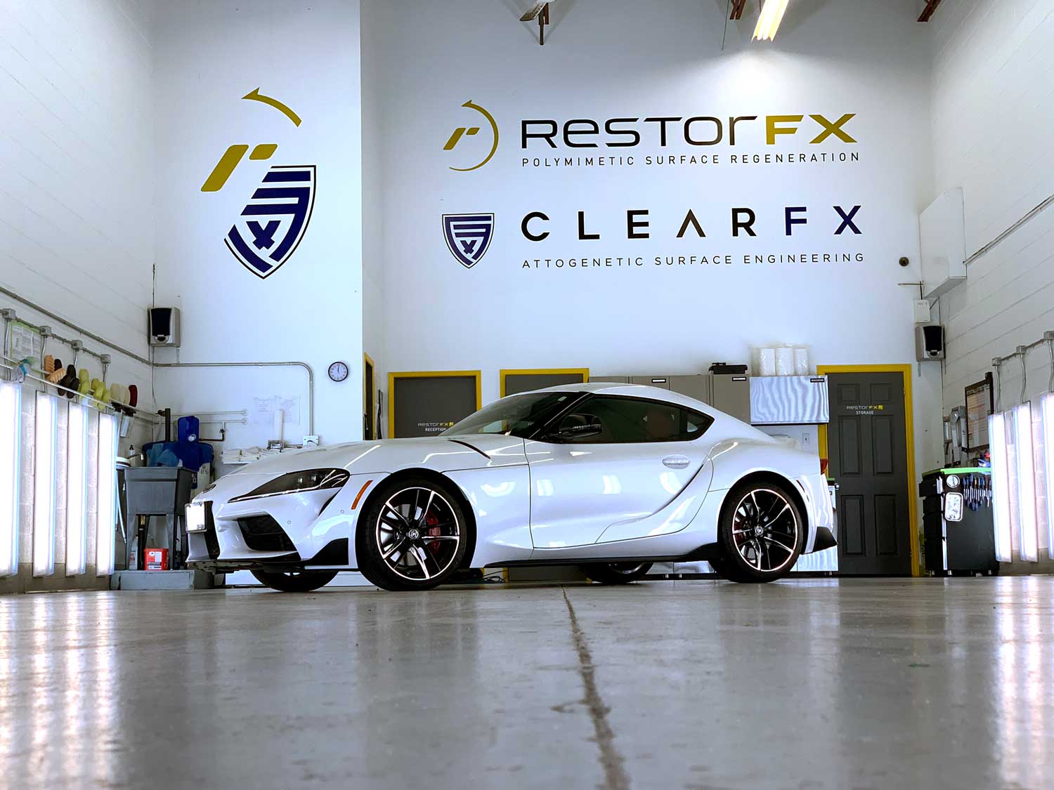 RestorFX GTA shop area with a white sports car inside the brightly lit facility with tall ceilings