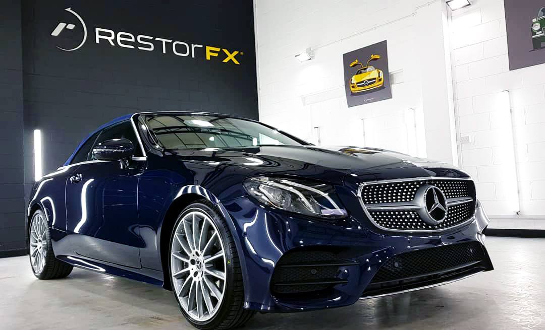 Shiny Mercedes-Benz at bright RestorFX Rotherham shop area with brick walls and branded signage