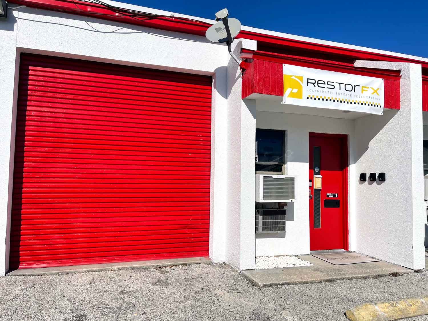 Inviting facade at RestorFX Jacksonville storefront with branded banner, parking area and blue sky