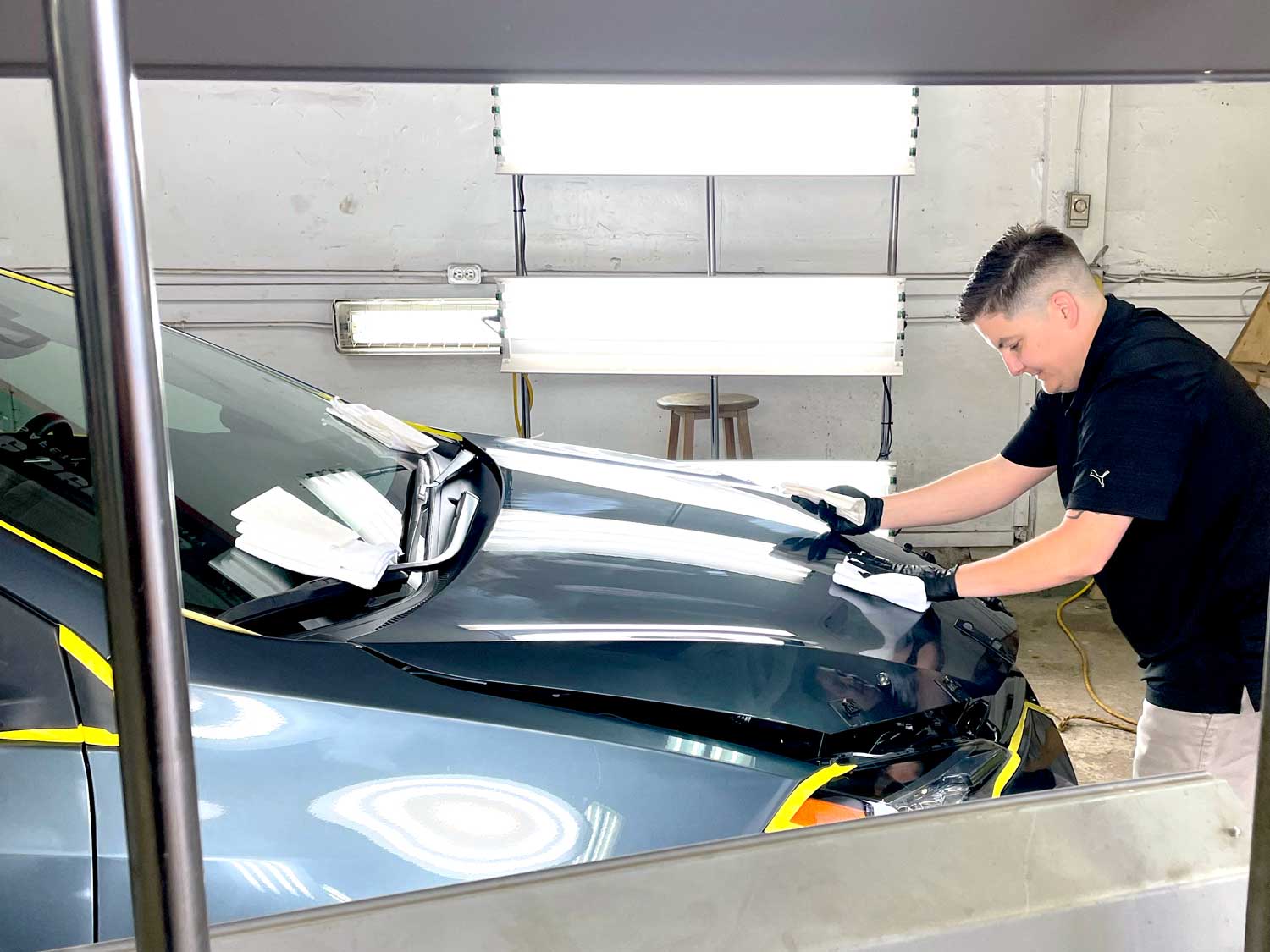 RestorFX Moncton technician applying product onto shiny vehicle surface during restoration process