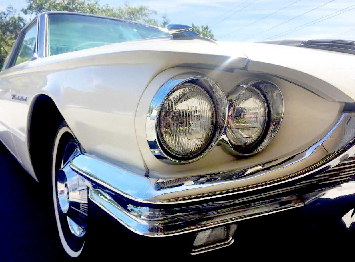 Antique ivory car with its shiny chrome front and classic headlights at RestorFX Grants Pass center