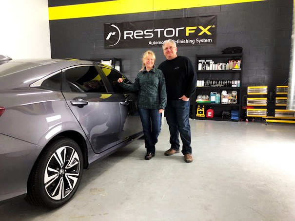 RestorFX Gainesville team at branded shop area posing next to shiny Honda after restoration process