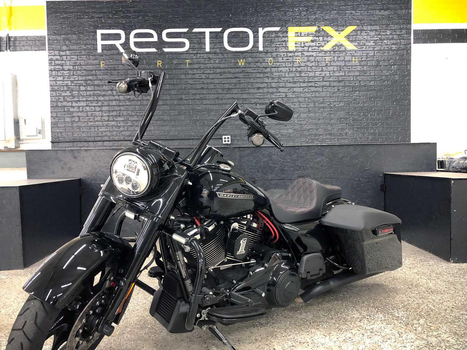 RestorFX Fort Worth interior feature wall with a brick wall treatment and a lustrous, shiny black Harley Davidson motorcycle