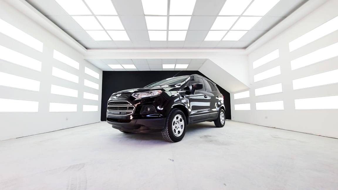 Shiny black vehicle in the center of brightly lit showroom at RestorFX Debrecen with light panels