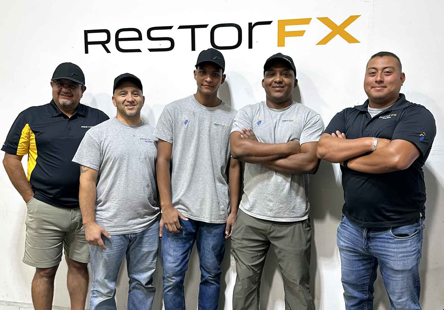 RestorFX Raleigh team in front of a white branded wall