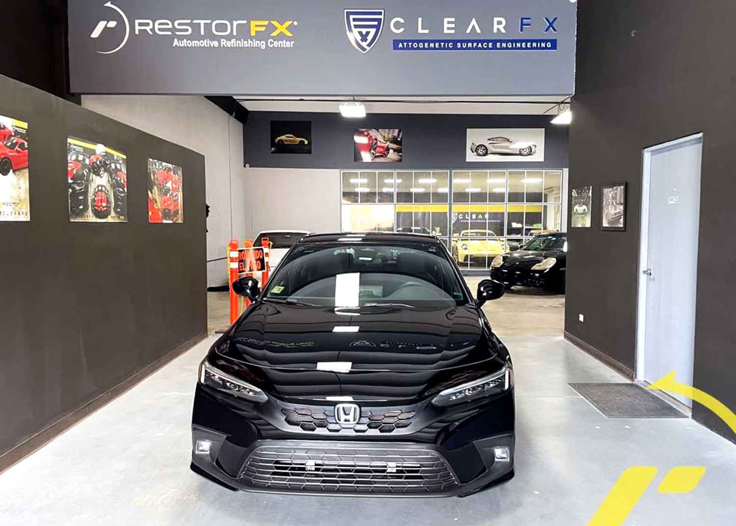 Black Honda car parked at the entrance to the RestorFX Puerto Rico center with logos in the background