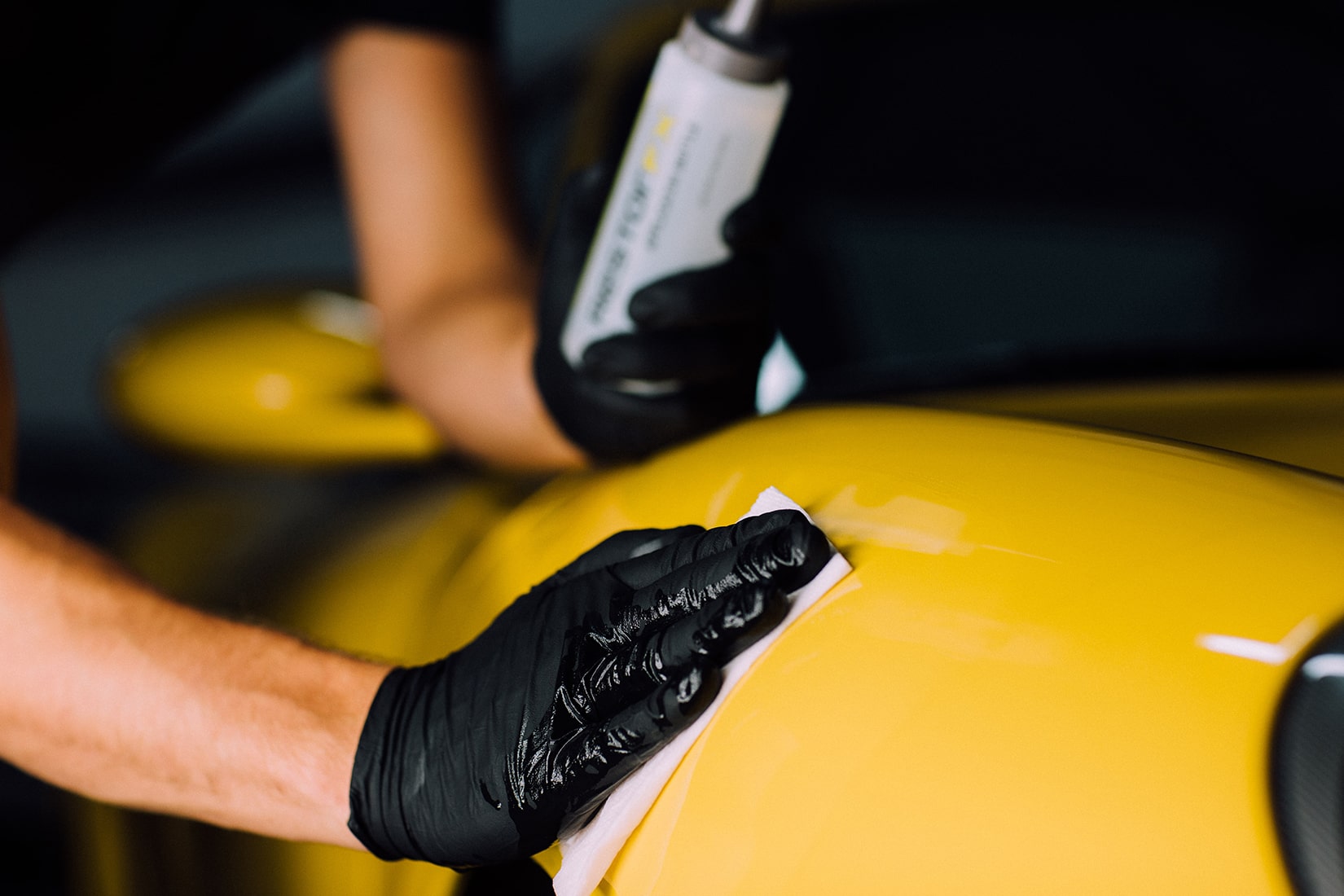 Un técnico de <span  class='notranslate'>RestorFX</span> que realiza un tratamiento de restauración en la superficie pintada de un automóvil deportivo amarillo debidamente preparado