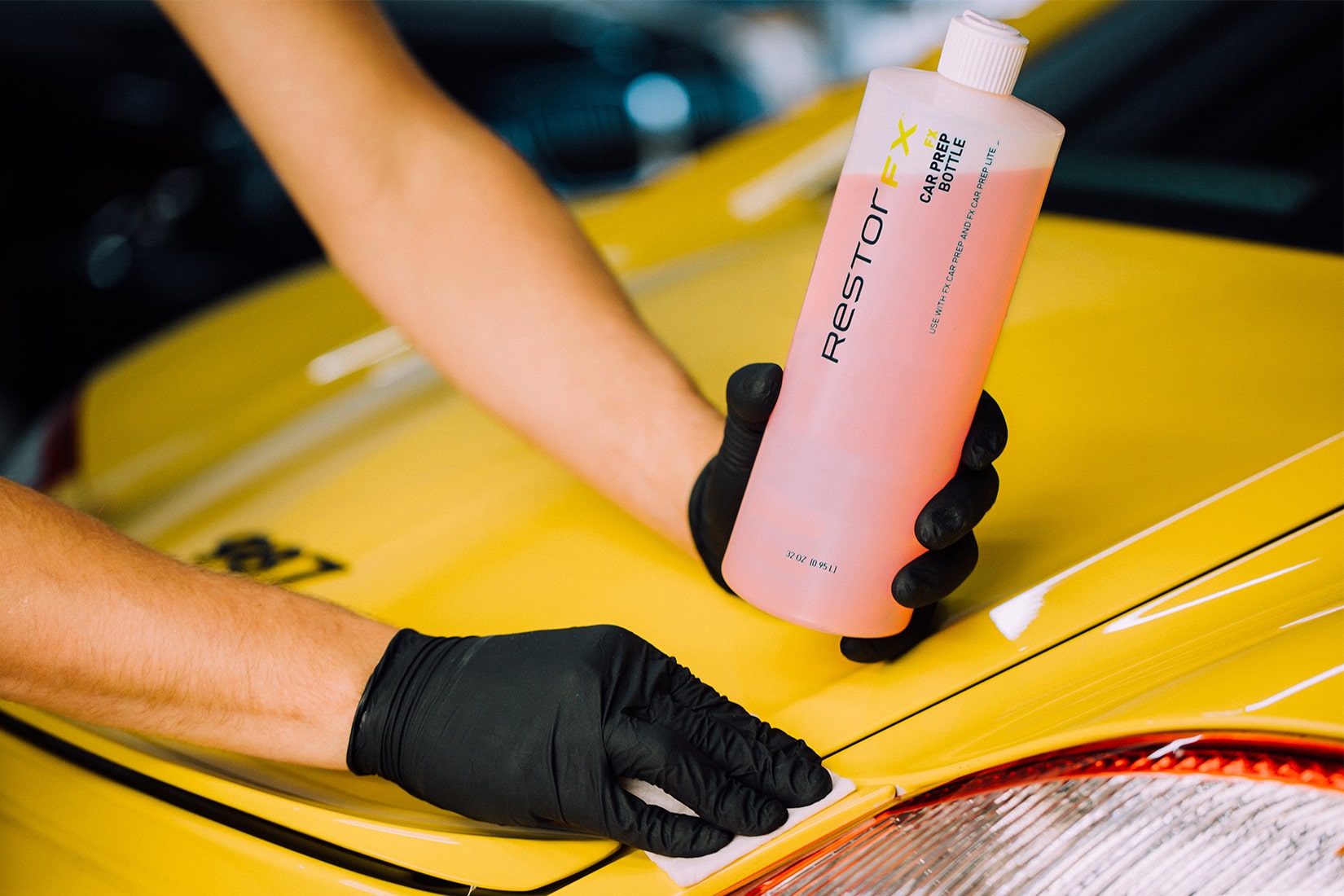 Um técnico <span  class='notranslate'>RestorFX</span> realizando um teste químico usando o FX Car Prep na superfície de um carro esportivo amarelo