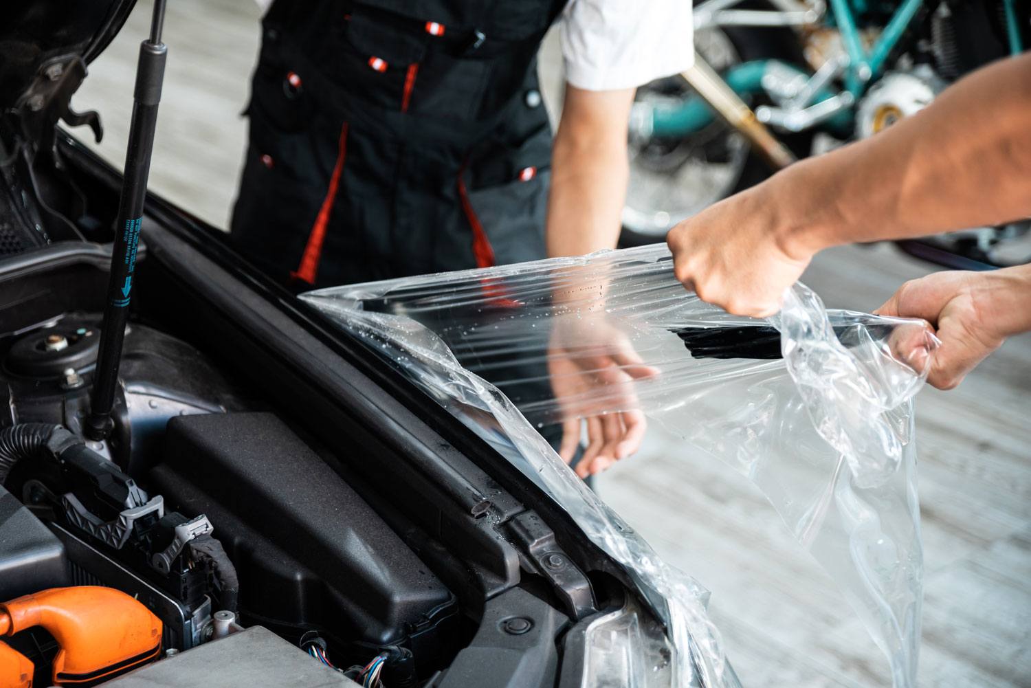 A technician carefully removing PPF from a car’s surface